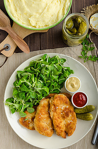 配马铃薯泥和沙拉的Schnitzel油炸面包屑盘子猪肉土豆蔬菜香菜美食鱼片牛扒图片