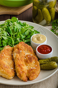 配马铃薯泥和沙拉的Schnitzel面包屑生物油炸香菜盘子蔬菜猪肉柠檬土豆鱼片图片