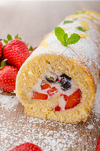 配有草莓和蓝莓的海绵卷糕点食物海绵面包巧克力奶油叶子早餐水果甜点图片