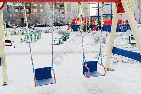 冬季游乐场上雪雪雪覆盖摇摆和滑动天气乐趣场景孩子们楼梯庭院操场游戏冻结公园背景图片