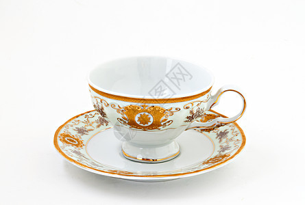 与黄金装饰品隔离的古老茶杯杯子制品古董叶子用具厨房文化男人飞碟陶瓷图片