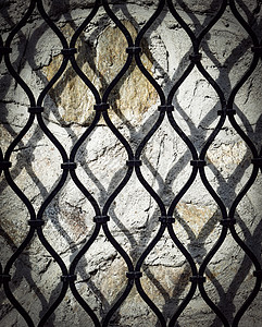 石墙上的黑色铁栅格背景图片