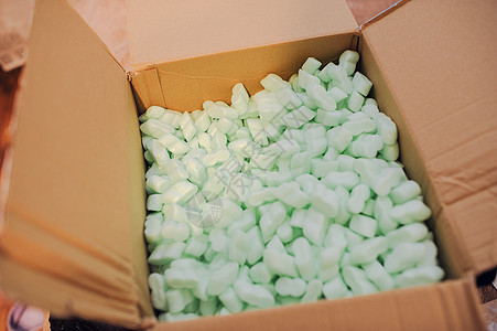 装满许多白色泡沫塑料颗粒的盒子棕色包装绿色水平材料空白填料邮件船运花生图片