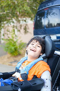 坐在轮椅上 在户外微笑的英俊双种族残疾男孩r医疗男生机动性矫形器孩子白色脑瘫需求少数民族图片