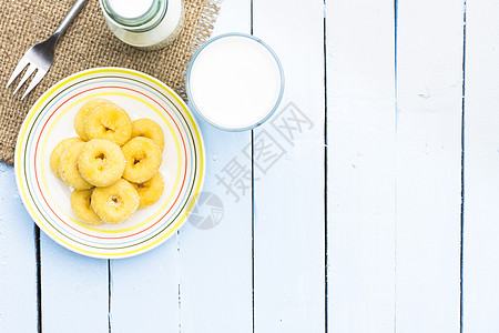 甜甜圈 奶瓶和牛奶杯 放在木制天空蓝桌上 麦片或早餐高维他明和钙图片