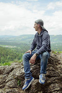 男人们休息 享受山的喜悦 坐在岩石上地平线旅行远足男人悬崖顶峰背包运动耐力活动图片