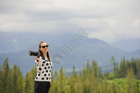 女摄影师在山上拍照片旅行女士假期背包相机闲暇远足者摄影女性游客图片