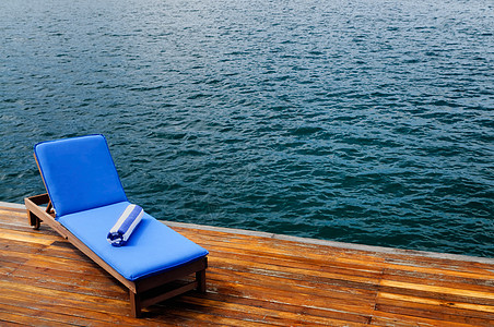 甲板上排舱外的坐席椅子温泉蓝色靠垫水平毛巾躺椅旅游奢华海岸背景图片