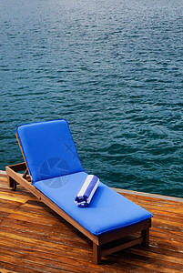 甲板上排舱外的坐席椅子海岸座位温泉躺椅热带靠垫奢华毛巾海洋背景图片