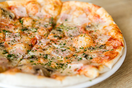 配蘑菇和火腿的披萨熏肉配料美食餐厅桌子饮食食物蔬菜脆皮盘子图片