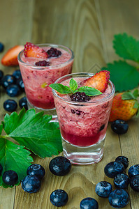 草莓果酱草莓冰淇淋 木制桌上有新鲜果子薄荷茶点食物紫色甜点覆盆子牛奶果汁玻璃水果背景
