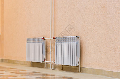 建筑物粉红色墙壁上的白色新散热器技术加热木地板力量温度空调活力安装现代性金属图片