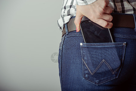 牛仔裤口袋里的智能手机海滩技术牛仔布互联网女孩屏幕商业女性电话图片