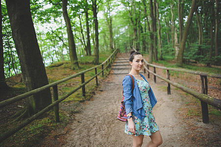 年轻女孩在森林里散步绿色远足小路游客树木女士旅行闲暇女性远足者图片