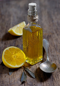 木制桌上的橄榄油和柠檬水果图片