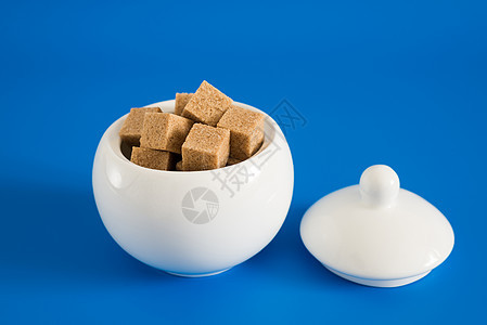 蓝底糖碗中粗糖的切片制品水晶厨房饮食活力食物陶瓷糖蜜甘蔗团体图片