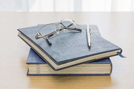 带眼镜和笔的黑色书学校大学小说图书馆文学科学故事皮革书签笔记本图片