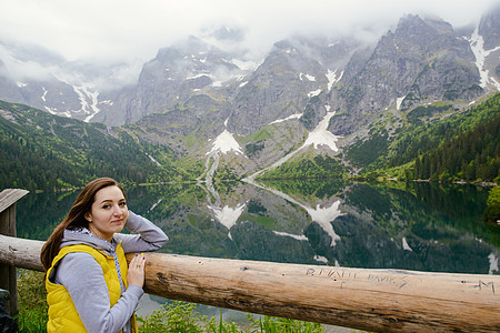 在湖边和山上放松的女士们 阳光明媚的风景蓝色绿色冒险岩石旅游旅行石头背包游客远足图片