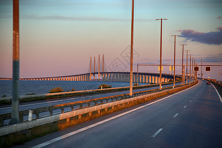 日落时见瑞典与丹麦之间的奥雷松桥建筑学交通地标天际旅行铁路商业天空运输图片