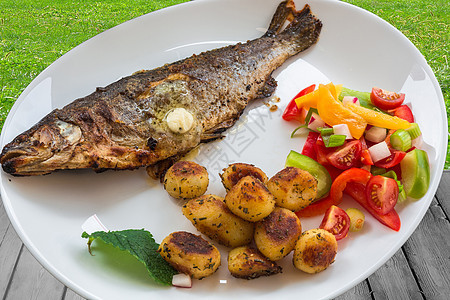白盘上的烤鳟鱼淡水杏仁桌子海鲜鱼片餐厅沙拉蔬菜土豆香菜图片