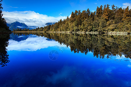 南岛新西兰州湖马济松山的反射风景天空木头旅行蓝色公园森林松树水池场景荒野图片