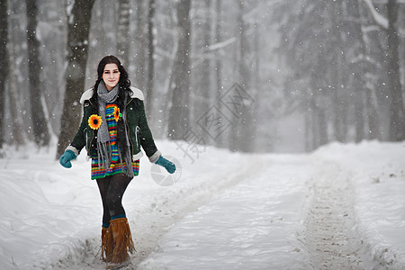 穿着毛衣的漂亮年轻美女 在公园中渡冬散步女性旅行森林围巾手套套衫远足长发微笑头发图片