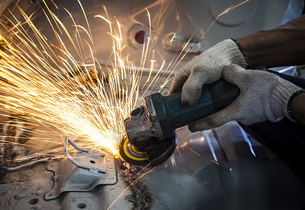 工业工具用手手工操作的工人 用分裂纤维切割钢铁磨床车轮焊接速度安全工厂研磨技术力量闪光图片
