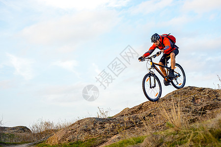 红夹克赛车队的女运动员 在下洛基山自行车赛场上 极具运动能力行动娱乐岩石乐趣男人成人头盔冒险爬坡下坡图片