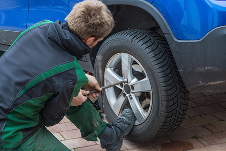 将夏季轮胎更换为冬季轮胎工作服技术员千斤顶橡皮减震器蓝色修复合金作坊维修图片