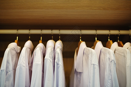 白衬衫挂在衣柜的衣架上图片