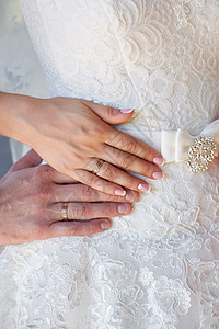 新娘和新郎的手带着新娘的礼服戒指图片