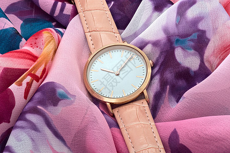 彩色丝绸布背景上的粉红手表图片