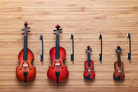一套4个玩具弦乐团乐器 小提琴 大提琴 反手法 木制背景的viola 四重奏 音乐概念图片