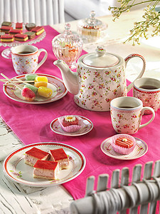 用粉红色桌布在桌上的高茶叶图片