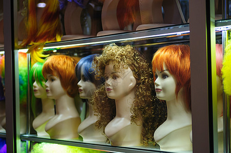 在有彩色头发的商店窗户上人体女士手臂浪费店铺塑料眼睛顾客理发师玩具图片