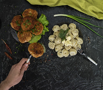黑色背景的炸薯片和俄罗斯薄膜饺子油炸木板营养香菜美食盘子牛肉奶油蔬菜图片