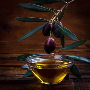 橄榄油和紫橄榄桌子美食木头绿色营养烹饪黑色水果叶子香料图片
