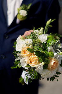 新郎拿着新娘的结婚花束图片