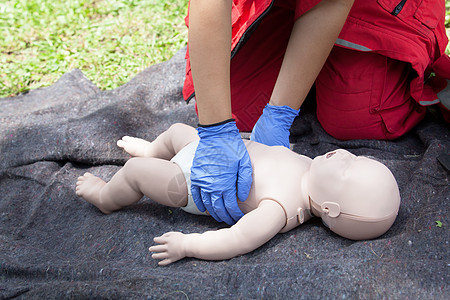 对婴儿假人进行心肺复苏CPR的辅助医疗演示伤口护理人员帮助考试伤害孩子手套疼痛药品训练图片
