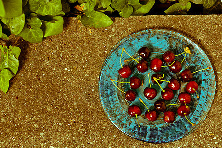 在灰石平板上的蓝盘上 美味的成熟樱桃食物甜点果味叶子水果美食浆果图片