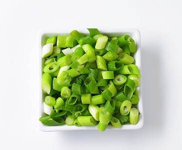 被压住的绿洋葱洋葱白色正方形盘子大葱蔬菜食物图片