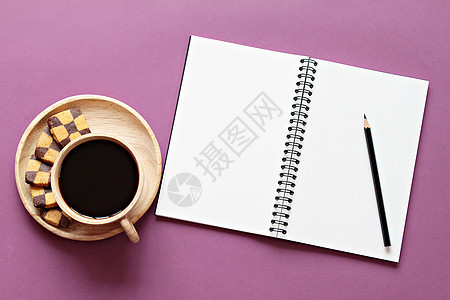 工作台的顶部视图与空白笔记本与和彩色背景上的咖啡杯图片