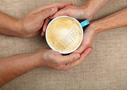 男人和女人手握着全拿铁咖啡杯手掌拥抱桌布牛奶杯子饮料女士白色时间帆布图片