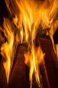 在壁炉里烧柴火 紧闭着木头黑色火焰红色橙子烧伤营火黄色日志煤炭图片