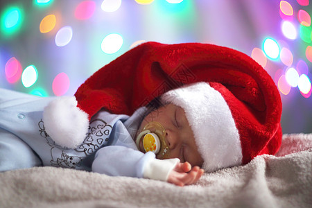 戴圣塔帽子的新生婴儿毯子童年毛巾魔法男生辉光说谎背景孩子休息图片