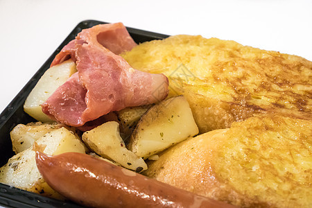 美味的早餐套餐放在黑色塑料托盘上油炸白色黄色食物猪肉香肠土豆营养图片