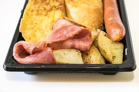 美味的早餐套餐放在黑色塑料托盘上猪肉油炸食物营养香肠白色黄色土豆图片