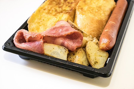 美味的早餐套餐放在黑色塑料托盘上营养食物香肠土豆猪肉黄色油炸白色图片