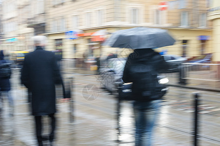 人们在雨中走在街上 注意力模糊黑色城市街道运动人群反射男人场景季节生活图片