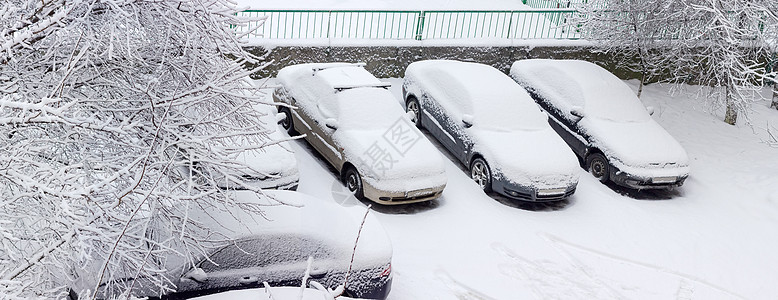 住宅区停车场被雪雪覆盖的车牌车图片